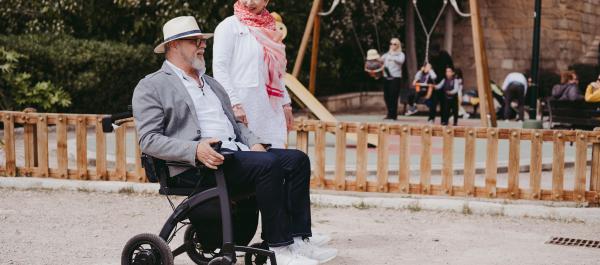 starsza para spaceruje na zewnątrz mężczyzna w wózku inwalidzkim
