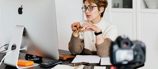 kobieta siedzi przed komputerem nagrywa szkolenie online