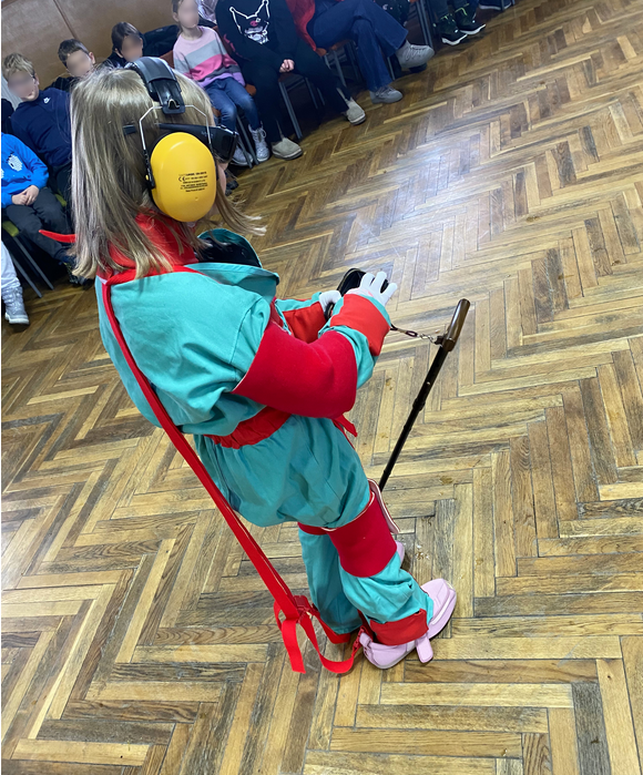 dziecko w kombinezonie geriatrycznym otwiera portfel
