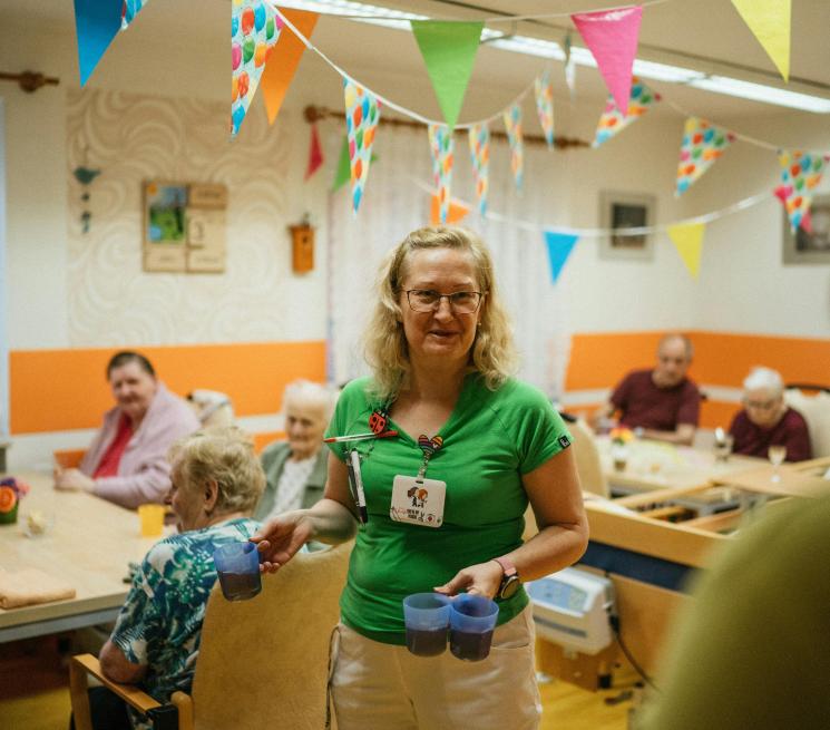 opiekunka roznosi jedzenie w placówce opiekuńczej dla seniorów