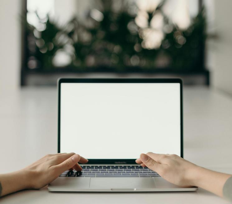 zdjęcie dłonie ułożone na klawiaturze laptopa w tle lustro