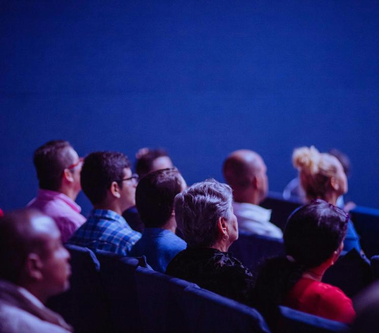 zdjęcie sala konferencyjna osoby siedzą w rzędach foteli zdjęciem tyłem