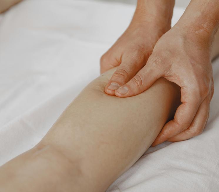 zdjęcie fizjoterapeuta masuje nogę pacjentowi