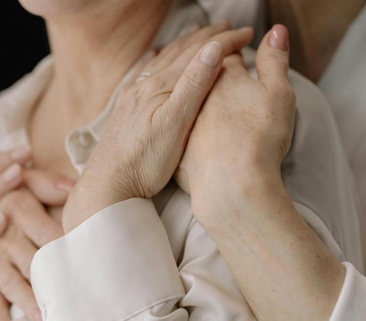 zdjęcie osoba obejmuje od tyłu drugą osobę trzymają się za ręcę 