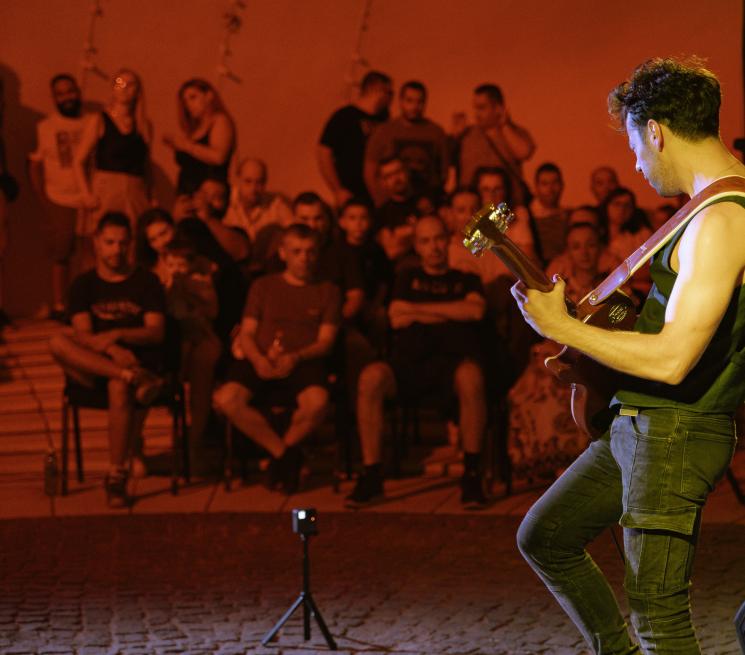 zdjęcie koncert w plenerze na pierwszym mężczyzna grający na gitarze w tle publiczność