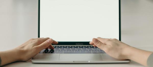 zdjęcie dłonie ułożone na klawiaturze laptopa w tle lustro