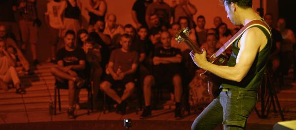 zdjęcie koncert w plenerze na pierwszym mężczyzna grający na gitarze w tle publiczność