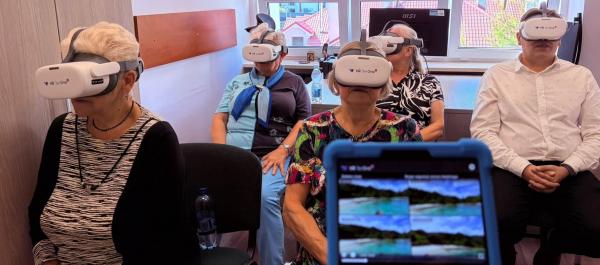 zdjęcie piątka osób z goglami VR siedzi na krzesłach