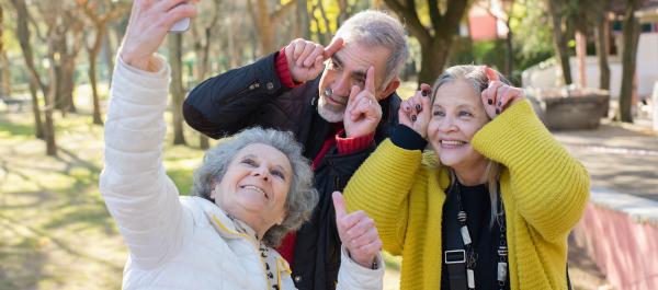zdjęcie trójka seniorów dwie kobiety i jeden mężyzna uśmiechnięci pozują do zdjęcia selfie