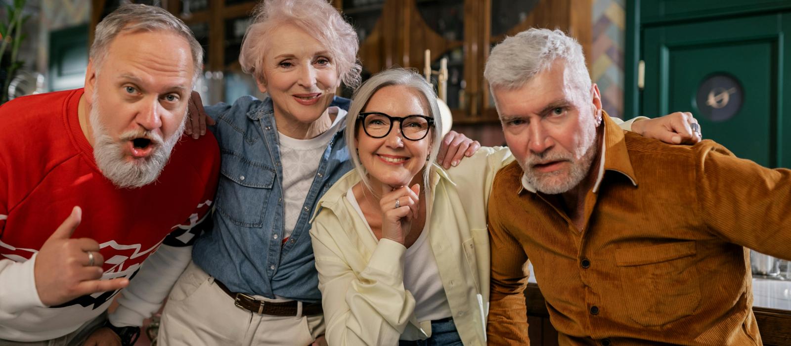 grupa czterech uśmeichniętych seniorów pozuje do zdjęcia