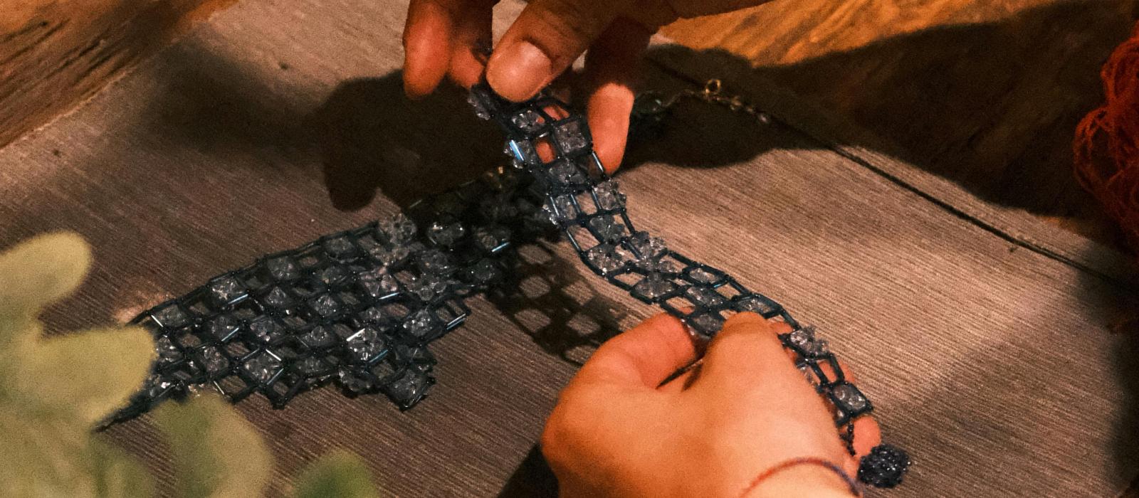 zdjęcie dłonie kobiety przygotowującej pracę artystyczną nakłada na obraz fragmenty materiału